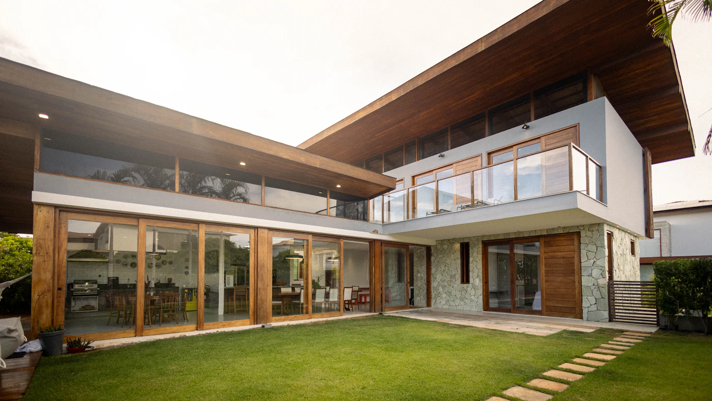 Modern two-storey home with walls of glass opening onto a green lawn